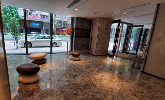 The building has a spacious lobby or entrance with large windows and marble tiled floors at Wharney Hotel