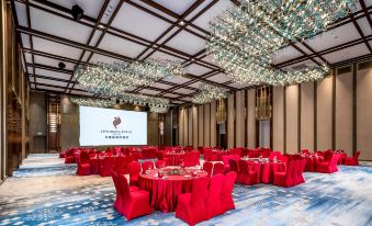 A ballroom is arranged for an event, featuring tables adorned with red and white chairs at LEFUQIANG BOYUE HOTEL