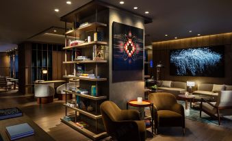 In front of the room, there are chairs and tables, and along the wall, there is an entertainment center at The Hari Hong Kong