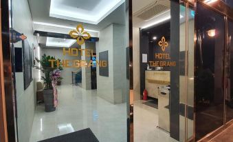 The hotel lobby features a glass fronted door and windows displaying the logo at Hotel the Grang Jungmun