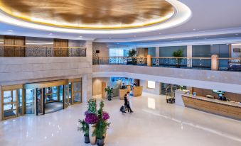 The main building features a spacious lobby with an atrium and floor-to-ceiling windows at Novotel Beijing Peace
