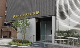 "the exterior of a hotel named "" hotel torifo "" with a sign above the entrance , and stairs leading up to the entrance" at Hotel Torifito Hakata Gion