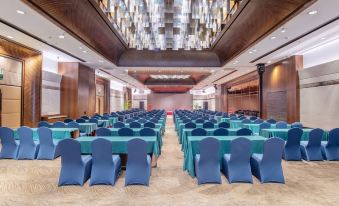 Rows of blue chairs face the front of a spacious event space, suitable for hosting official weddings at Mission Hills Resorts Shenzhen