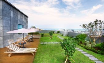 a tropical backyard with a pool , umbrellas , and plants is shown next to the ocean at Hotel the One