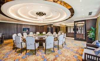 A spacious event space is arranged with tables and chairs in the center at Hainan Guest House No.2 Building