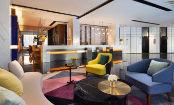 The living room is furnished with couches, chairs, and side tables at Hampton by Hilton Yiwu International Trade Market