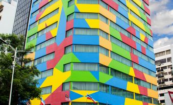A large building with various colors and shapes on its exterior, including an art deco design at Hotel Capital Kota Kinabalu