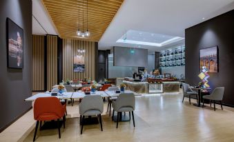There is a restaurant in the center with tables and chairs, as well as additional seating areas at Park Inn by Radisson Beijing Tongzhou Universal Resort