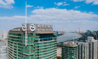 From a high vantage point, a prominent building displaying its name and city is visible at The Eton Hotel Shanghai