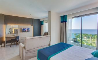 a modern hotel room with a large window offering a view of the ocean , a bed , and a couch at Falcon Hotel