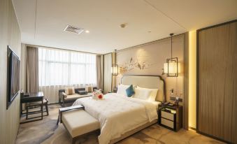 The middle room features a spacious bed with an adjoining sitting area and a nearby table at Baiyun Hotel