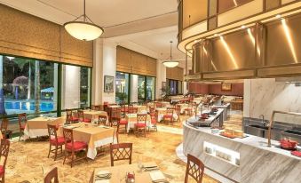 The restaurant features a spacious dining room with tables and chairs, ideal for hosting business luncheons at Hanoi Daewoo Hotel