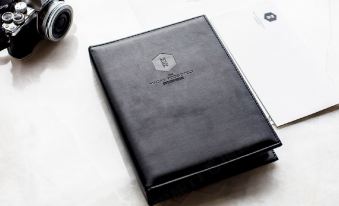 The leather notebook is black and silver and features an open pocket on top at The Macau Roosevelt