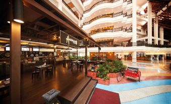 a large hotel lobby with a staircase leading up to the second floor , and a dining area on the second floor at Resorts World Kijal