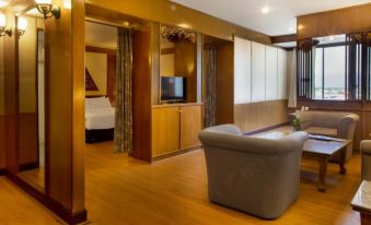 a hotel room with a comfortable bed , a couch , and a tv . the room is well - decorated and appears to be clean at Phrae Nakara Hotel