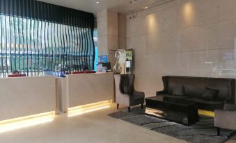 The lobby features a spacious living room with a large window, modern furniture, and marble countertops at Tourism Trend Hotel