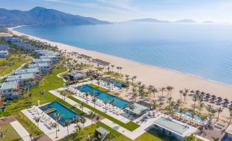 a large resort with multiple pools , palm trees , and a beach is shown from an aerial view at Alma Resort Cam Ranh