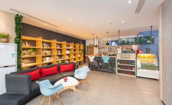 The restaurant features a central area with tables and chairs, as well as an open concept space housing a bar and lounge, creating a welcoming and cozy environment for guests to enjoy their meals and unwind at Ibis Hotel (Shanghai New International Expo Center Lianyang Branch)