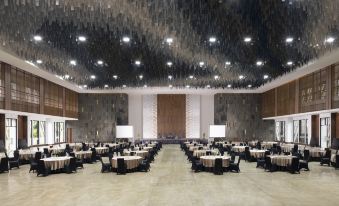 a large banquet hall with multiple dining tables and chairs set up for a formal event at Jsi Resort