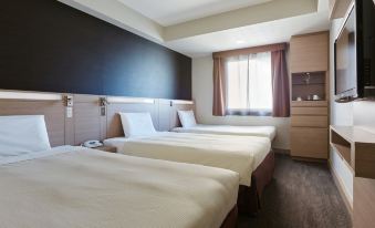 a hotel room with three beds , two of which are twin beds and one is a double bed at Mitsui Garden Hotel Okayama