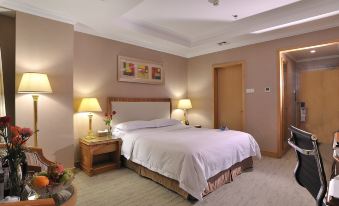 a well - lit hotel room with a king - sized bed , two nightstands , and a painting on the wall at Phoenix Hotel
