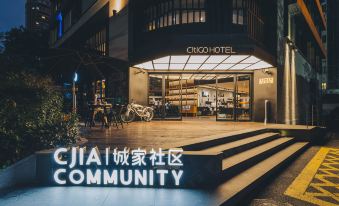 At night, there is a restaurant entrance with a sign in front, surrounded by other buildings at CitiGO Hotel Jing'an Shanghai
