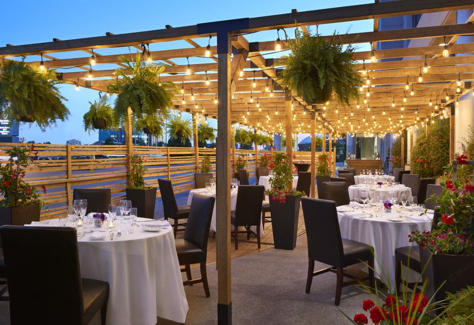 an outdoor dining area at a restaurant , with tables and chairs set up for guests to enjoy their meal at Sheraton Parkway Toronto North Hotel & Suites