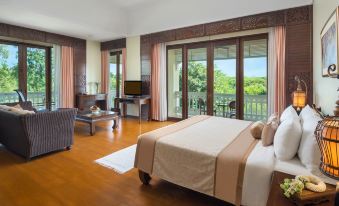 a spacious bedroom with hardwood floors , a large bed , and a tv mounted on the wall at Dheva Mantra Resort