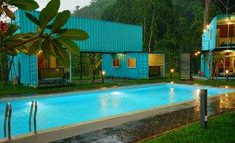 a large outdoor swimming pool surrounded by a wooden house , with a blue tarp covering the ground at Sarang by the Brook
