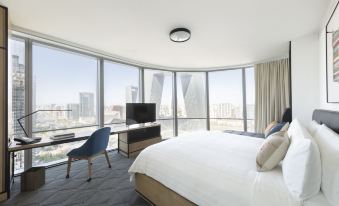 The bedroom features large windows and a balcony that overlook the city at night, as well as two white at Jen Beijing by Shangri-La