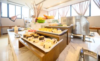 a dining room with a buffet table filled with a variety of desserts , such as cakes , cupcakes , and pastries at Como Hotel