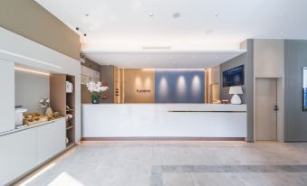 The reception desk is situated in a modern and contemporary living and dining room at Home·NEO Hotel (Guangzhou Exhibition Center Pazhou Metro Station)