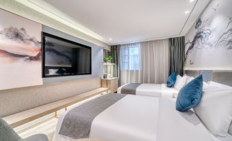 The main bedroom features modern decor, including double beds, large windows, and a flat-screen TV at Weiting Century Hotel