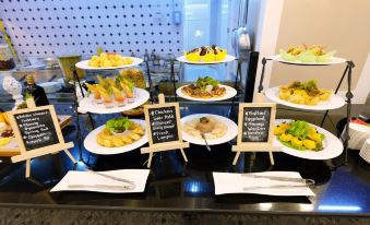"a buffet table filled with a variety of dishes , including multiple plates of food and a sign displaying the name "" coriander mustard ""." at Rizal Park Hotel