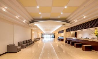 a large , modern hotel lobby with a long hallway and several chairs arranged for guests at Hotel Urashima