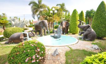 a beautiful garden with a water fountain surrounded by various statues of elephants , including one in the center at Tokyo Hotel