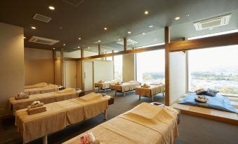 a large room filled with rows of massage tables , each covered in a beige towel at Hotel Clad