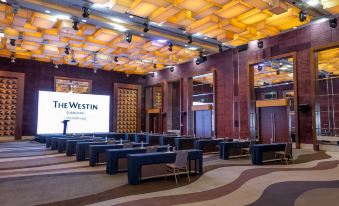 A spacious room with rows of chairs facing an illuminated screen on the front wall at the Westin Guangzhou