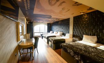 a hotel room with four beds , two of which are on the left side of the room and one on the right side at Arthouse Hotel