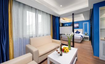 a spacious living area with white furniture and a connected bedroom at European Style Theme Smart Hotel (Yiwu International Trade City District 2 and 3)
