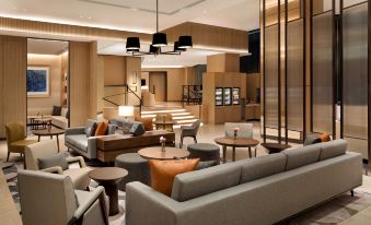 The lobby is decorated with couches and tables, creating a welcoming atmosphere at Hyatt Place Shanghai Hongqiao CBD