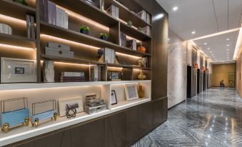 The wall is adorned with books and decorative lighting, creating a modern ambiance suitable for a living room or office at Mercure Hotel (Shanghai Hongqiao Railway Station)