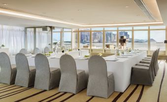 A room is set up with large windows and tables for an event or conference at The Royal Pacific Hotel and Towers