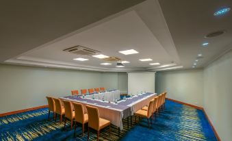 a conference room set up for a meeting , with a long table and chairs arranged in a semicircle at Hotel Sea Cliff