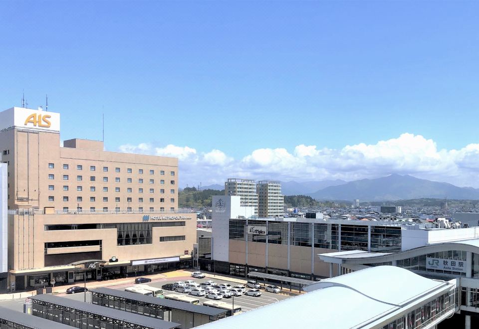 a city skyline with buildings , including a hospital and a hospital where a blue sky with clouds is visible at Hotel Metropolitan Akita