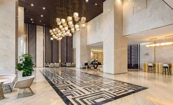a large , well - lit hotel lobby with marble walls , hardwood floors , and a marble floor design at Melia Vinpearl Hue