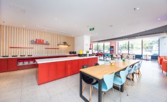 The restaurant features a modern open concept space with tables and chairs at Ibis Hotel (Shanghai New International Expo Center Lianyang Branch)
