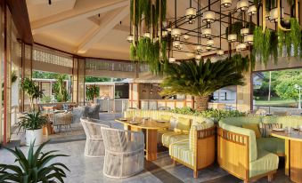 an outdoor restaurant with a large dining table surrounded by chairs and a variety of seating options at Dusit Thani Hua Hin