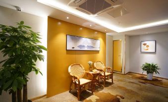 a cozy living room with two chairs placed in front of a large flat - screen tv mounted on the wall at Orient Hotel