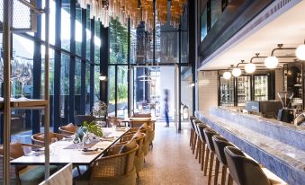 diners to enjoy their meals while taking in the view through the expansive windows at HOMM Sukhumvit34 Bangkok - a brand of Banyan Group